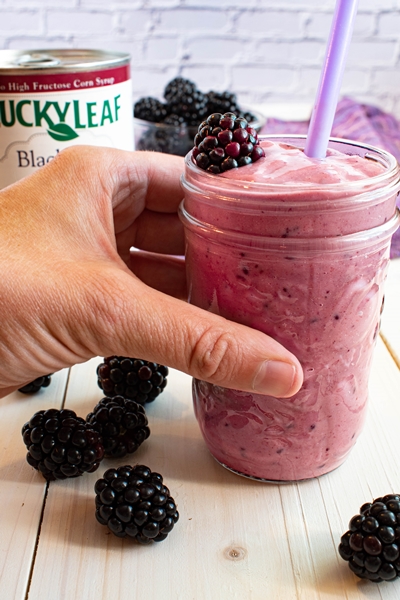 Blackberry Pie Smoothie with pie filling can and hand